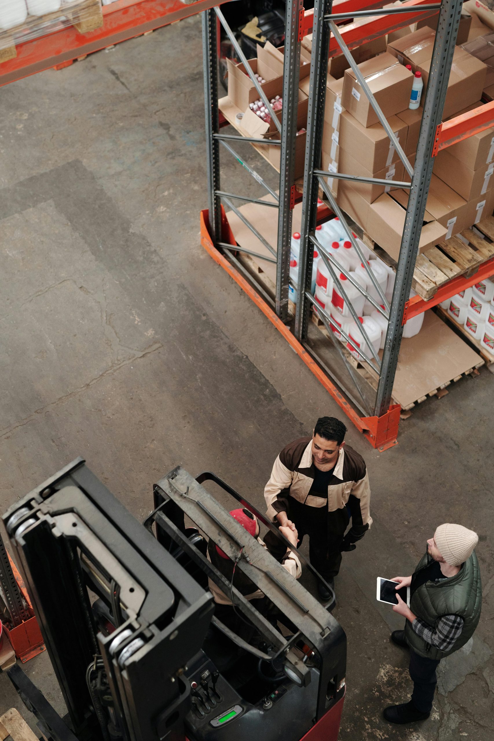 High angle view of staff collaborating in a warehouse, showcasing teamwork and logistics.